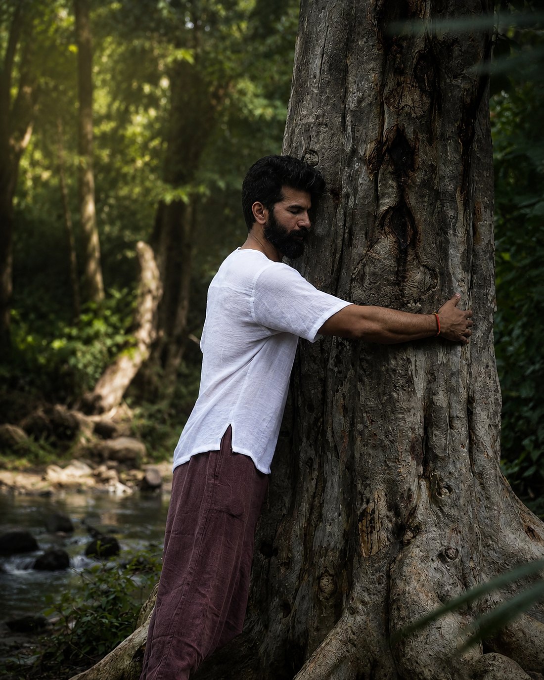 Resting against an old tree beside the stream